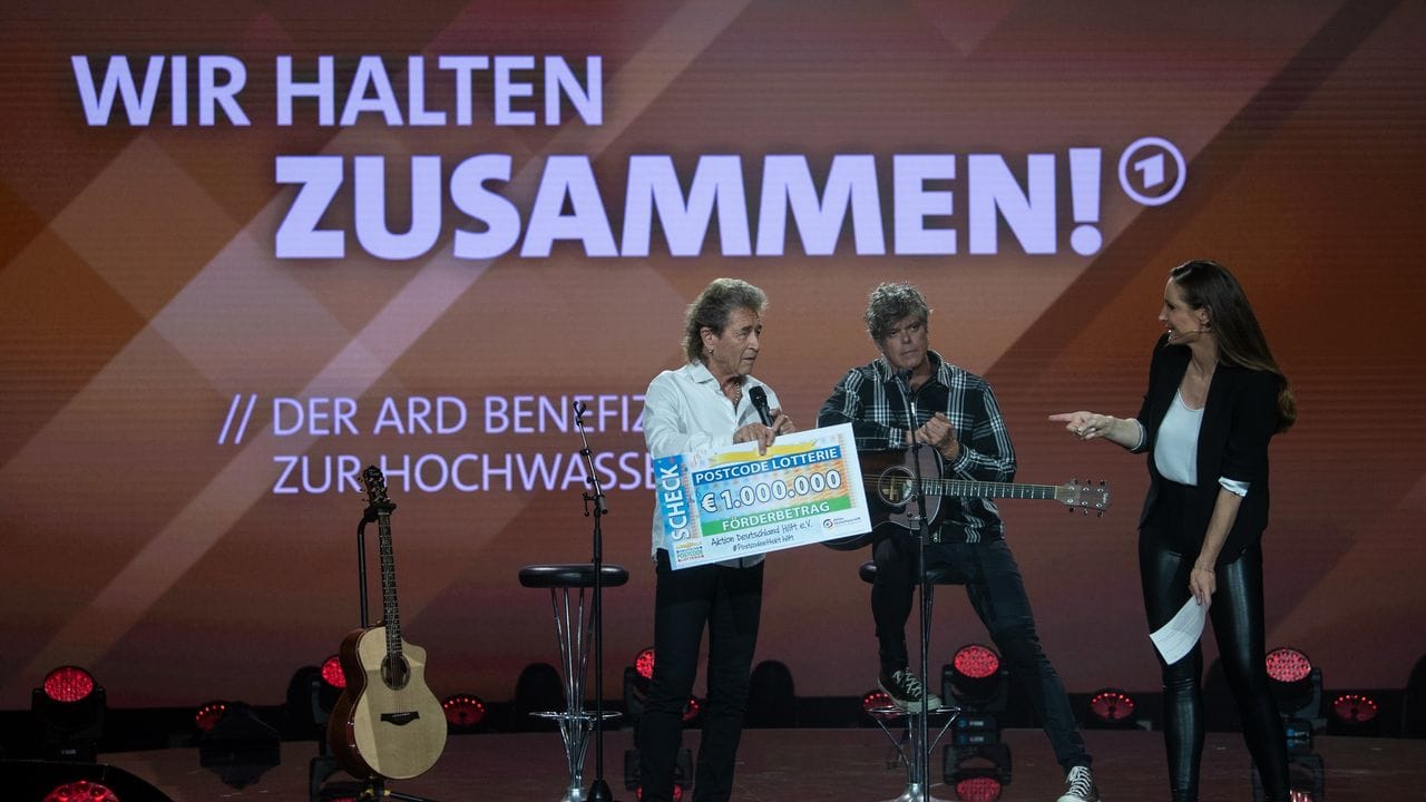 Der deutsche Sänger Peter Maffay (l) überreicht Moderatorin Sarah von Neuburg auf der Bühne der ARD-Benefizgala einen Spendenscheck.