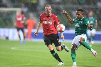 Werders Felix Agu (r) kommt vor Hannovers Marvin Ducksch an den Ball.