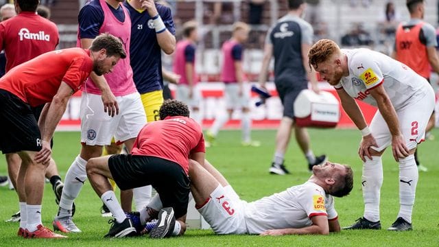 Kiels Marco Komenda wird auf dem Platz behandelt während Kiels Mikkel Kirkeskov (r) zuschaut. Der Abwehrspieler hat sich den Mittelfuß gebrochen. Kiels Marco Komenda wird auf dem Platz behandelt während Kiels Mikkel Kirkeskov (r) zuschaut. Der Abwehrspieler hat sich den Mittelfuß gebrochen.