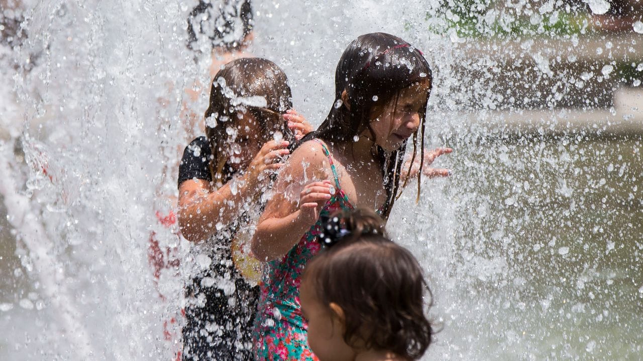 Kinder kühlen sich in Toronto in einem Brunnen ab.