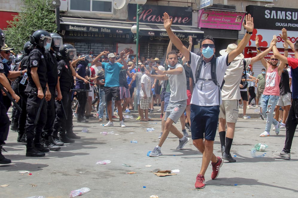 Uniformierte Polizisten stehen in Tunis Demonstranten gegenüber: Nach der Entmachtung der tunesischen Regierung hat US-Außenminister Antony Blinken zum Dialog zwischen den Konfliktparteien aufgerufen.
