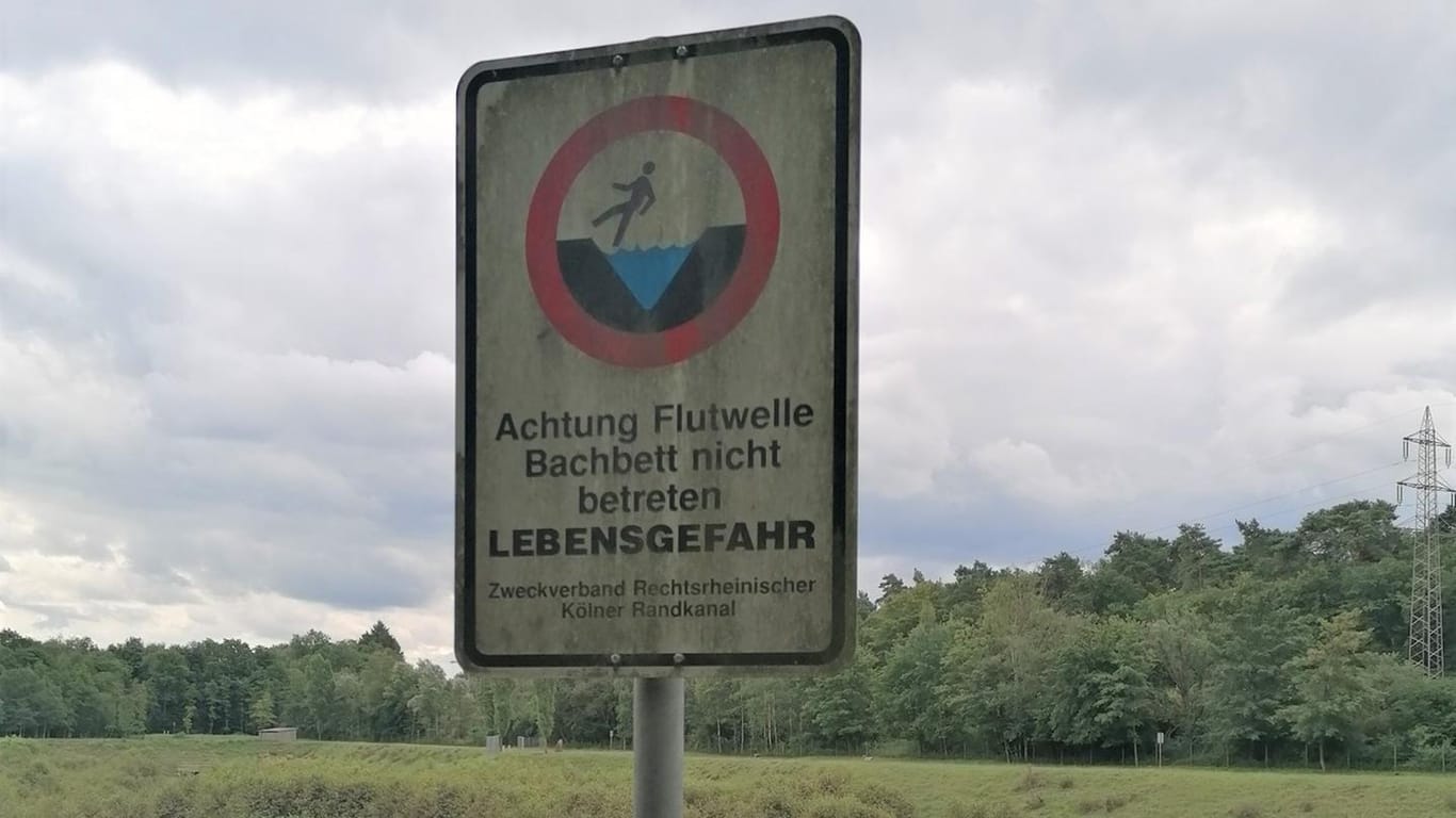 Ein Schild am Rückhaltebecken an der Diepeschrather Mühle warnt vor Überflutungen: In Dünnwald hat das Unwetter erhebliche Schäden angerichtet.
