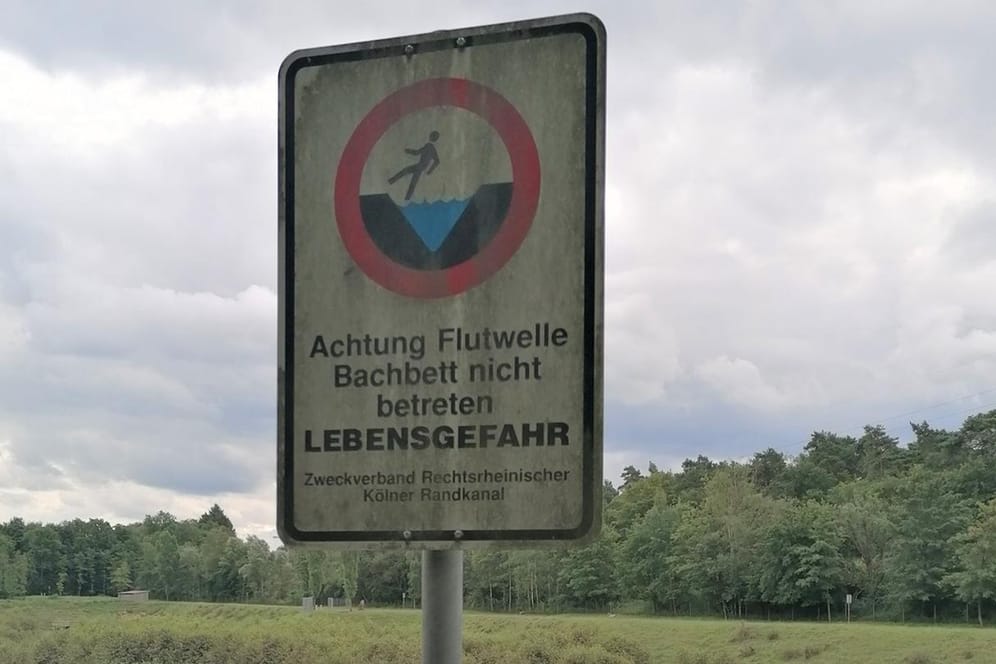 Ein Schild am Rückhaltebecken an der Diepeschrather Mühle warnt vor Überflutungen: In Dünnwald hat das Unwetter erhebliche Schäden angerichtet.