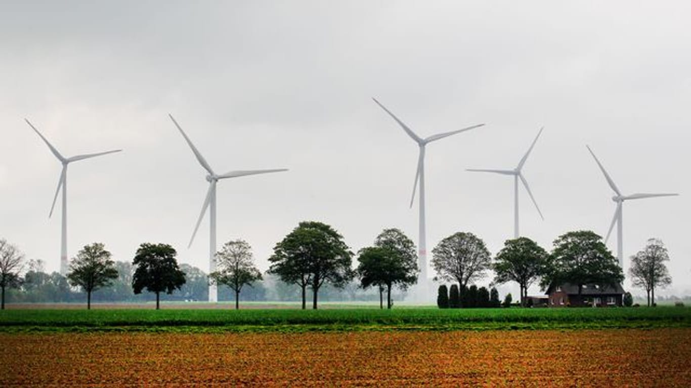 Windkraftanlagen drehen sich hinter Feldern