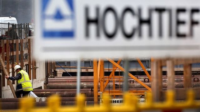 Das Logo von Hochtief hängt an einer Baustelle