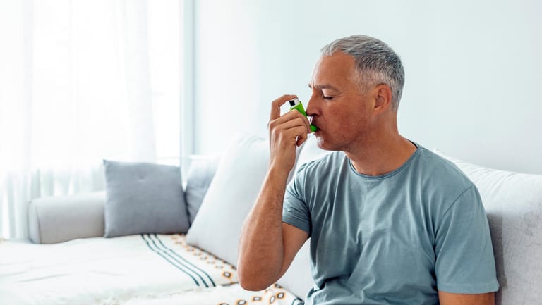 Mann mit Inhalationsgerät: Kortisonhaltige oder bronchienerweiternde Medikamente bei COPD zu inhalieren hat den Vorteil, dass die Wirkstoffe direkt in die Lunge gelangen.