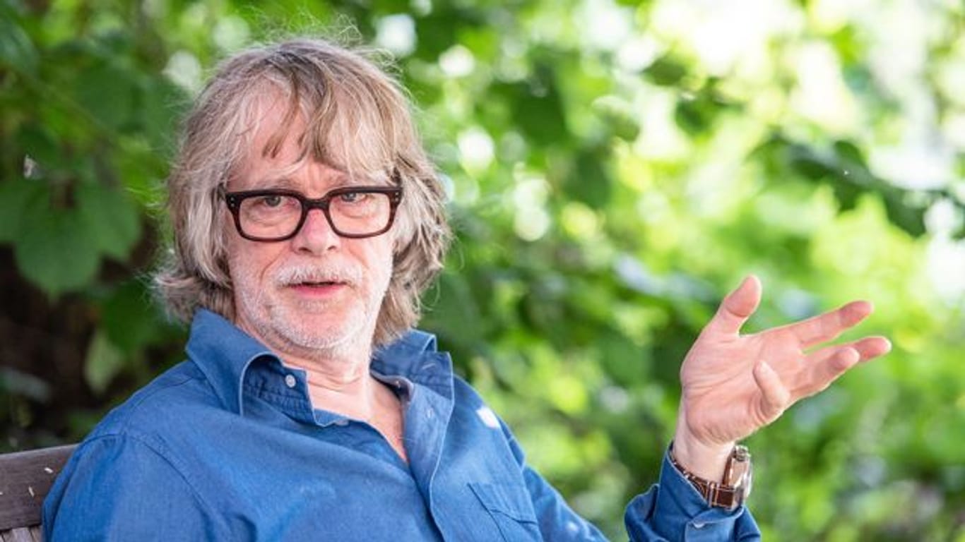 Helge Schneider, Musiker, spricht in seinem Garten mit einem Journalisten.