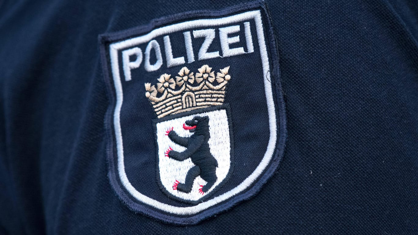 Das Logo der Berliner Polizei auf einer Uniform (Symbolbild): In Berlin durchsucht die Polizei Dutzende Objekte.