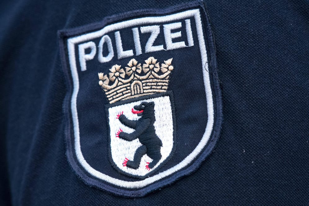 Das Logo der Berliner Polizei auf einer Uniform (Symbolbild): In Berlin durchsucht die Polizei Dutzende Objekte.