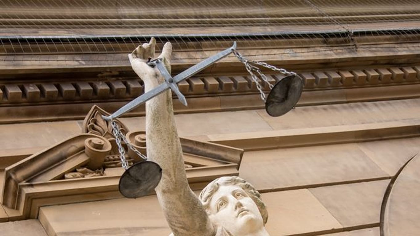 Eine Statue der Justitia hält eine Waagschale