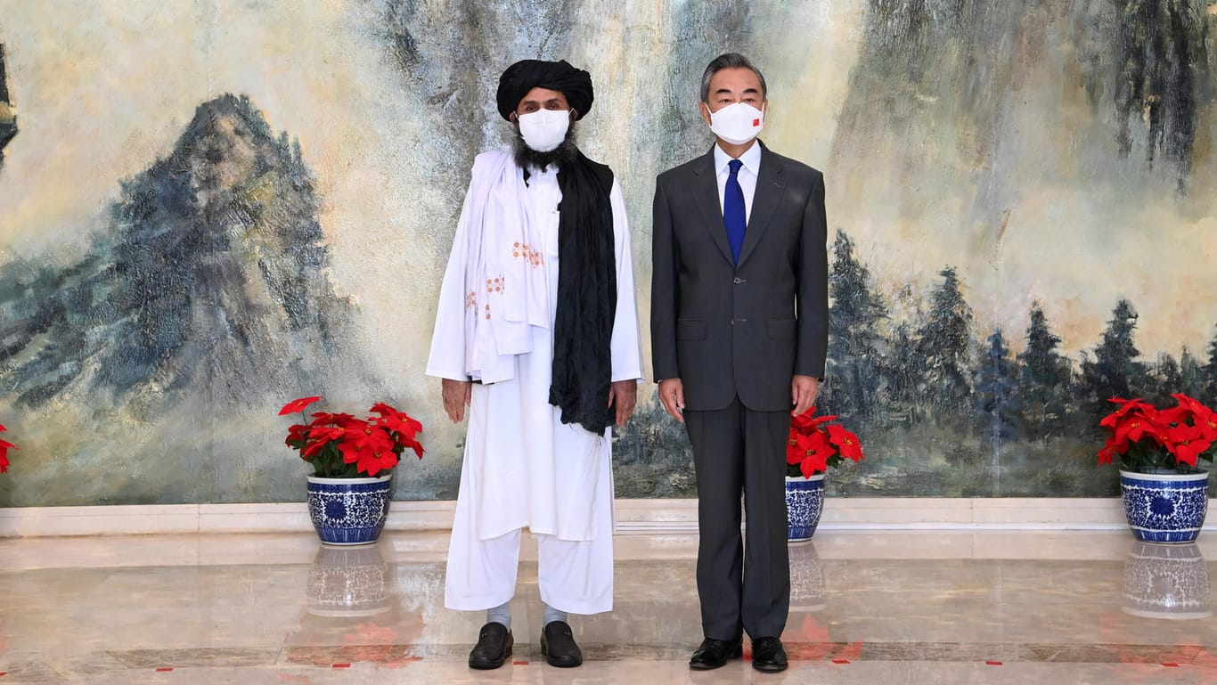 Mullah Abdul Ghani Baradar, afghanischer Führer der Taliban (l) und Wang Yi, Außenminister von China: Stabilität in Afghanistan würde China neue wirtschaftliche Möglichkeiten eröffnen.