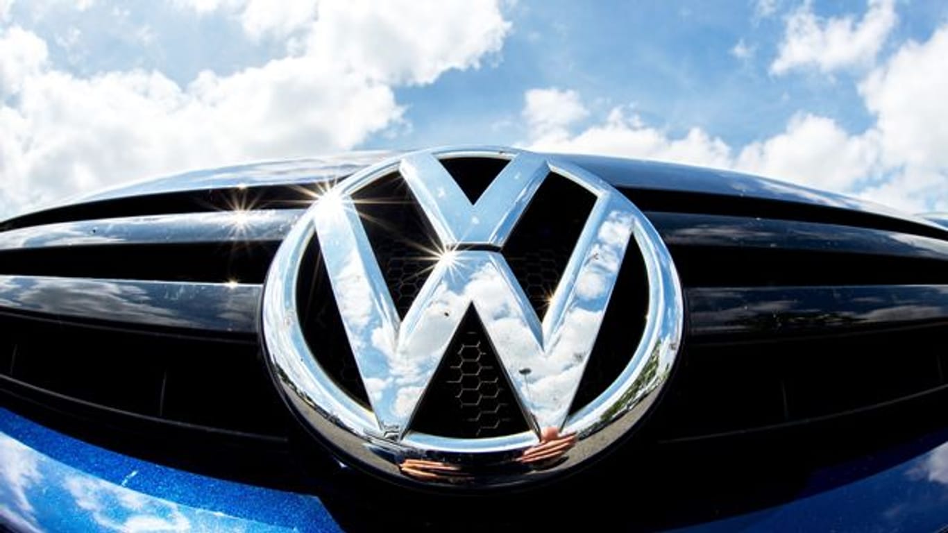 Das Logo von Volkswagen glänzt an einem Auto in der Sonne