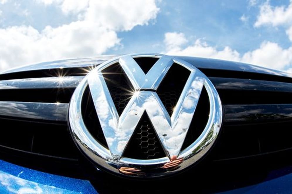 Das Logo von Volkswagen glänzt an einem Auto in der Sonne