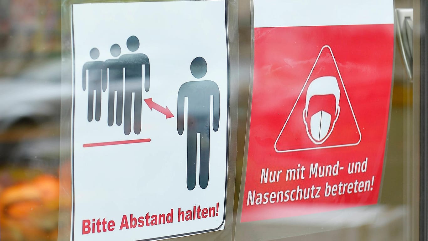 Schilder weisen an einem Geschäft auf die Maskenpflicht und die Abstandsregeln hin (Symbolbild): In Leipzig könnte die Maskenpflicht in Geschäften zurückkehren.