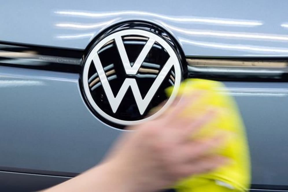 Eine Mitarbeiterin poliert ein Fahrzeug von VW