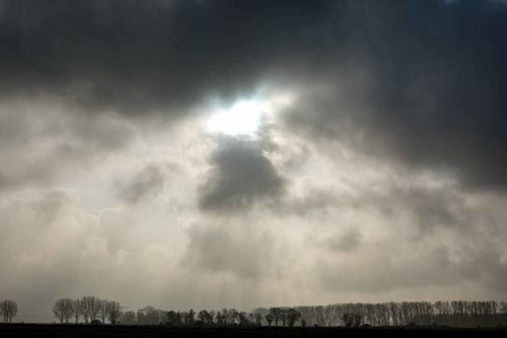 Die Sonne kommt hinter einer dunklen Wolkendecke hervor