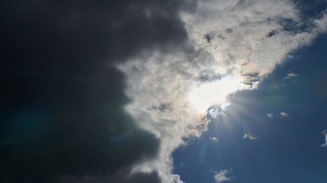 Die Sonne kommt hinter Regenwolken hervor