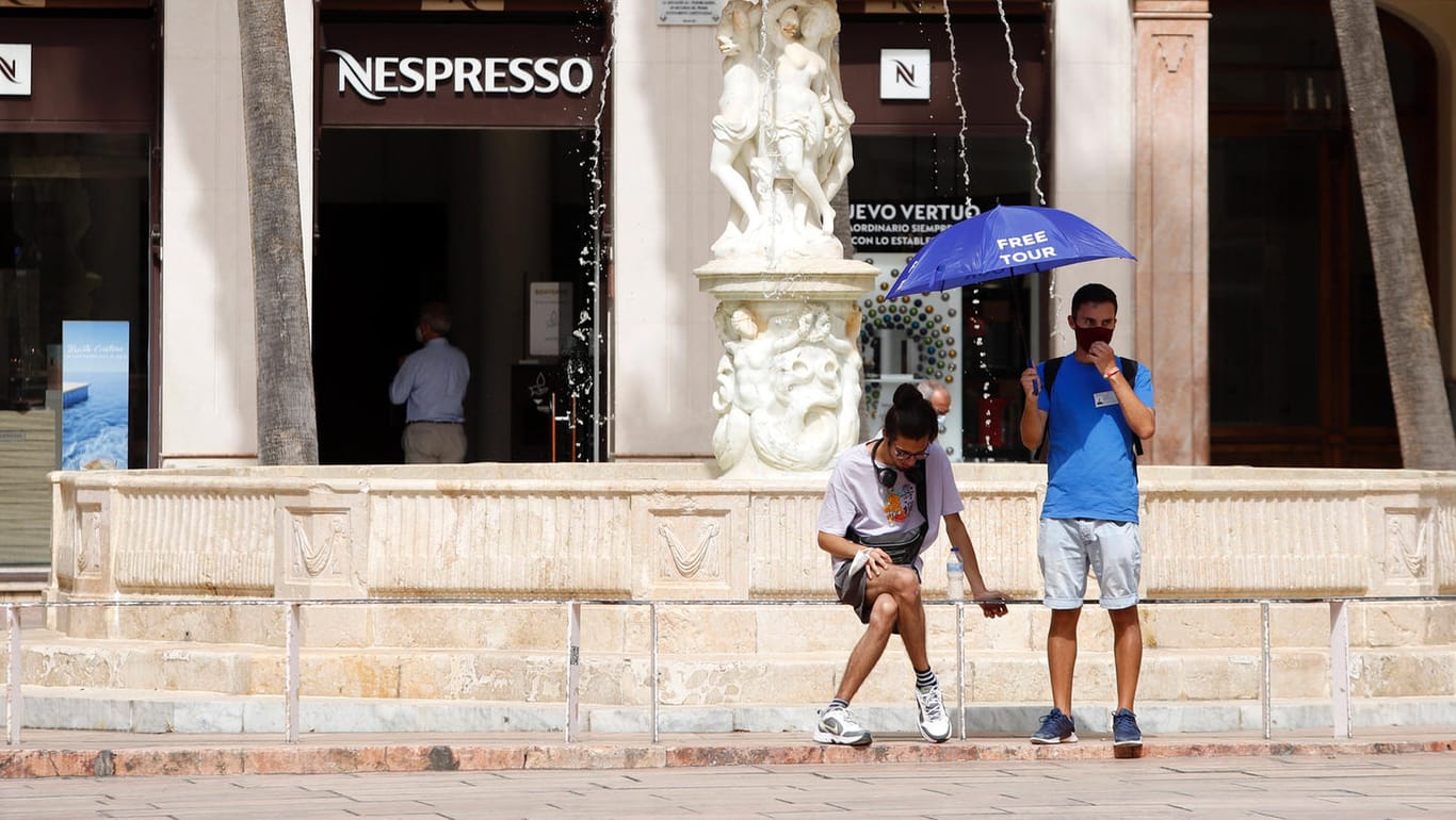 Touristenführer im spanischen Malaga schützen sich vor der Sonne: Anfang Juli wurde die Urlaubsregion von einer Hitzewelle heimgesucht.