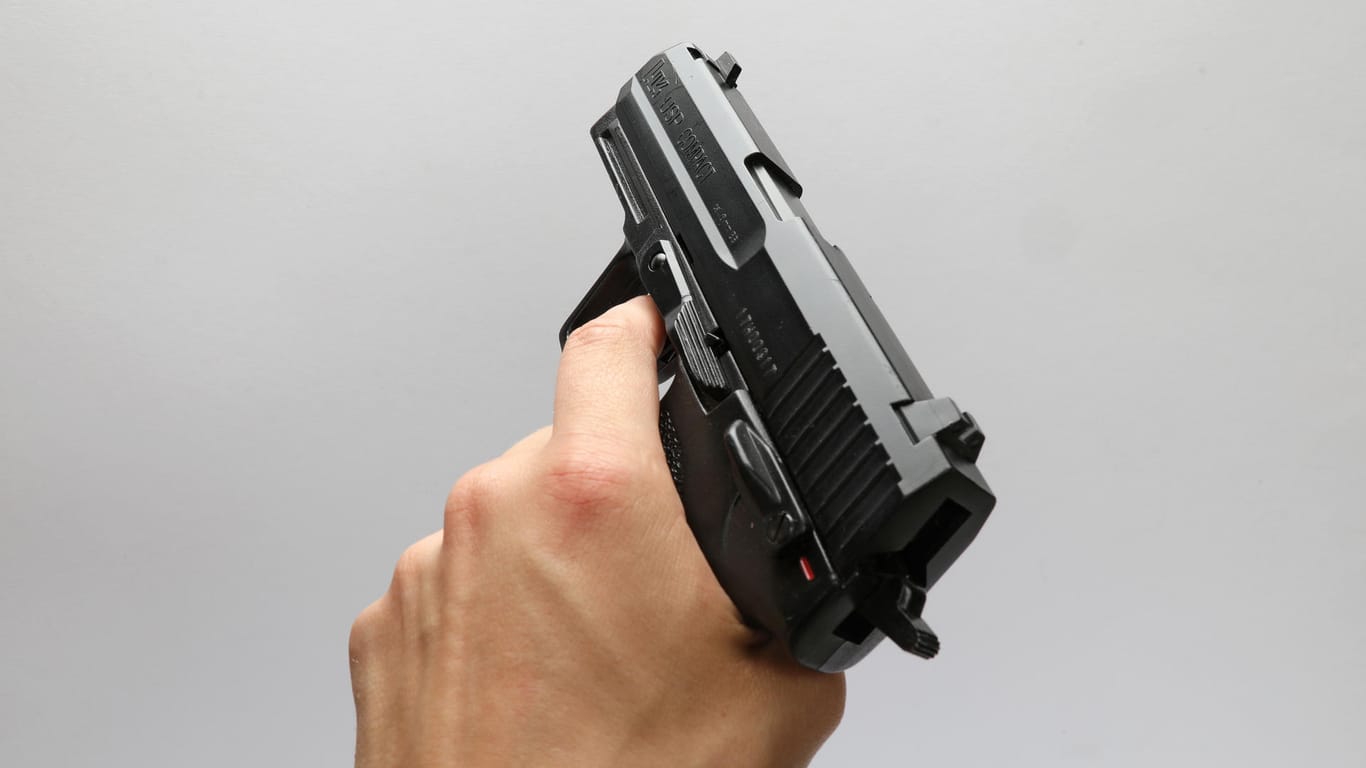 Jemand hält eine Softair-Pistole in der Hand (Symbolbild): Laut lachend soll der Mann mit der Waffe die Bahn betreten haben.