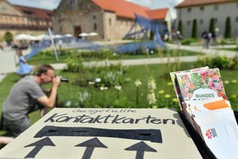 "Ausgefüllte Kontaktkarten" steht auf einem Karton mit Einwurf am Eingang zum Bundesgartenschau-Gelände auf dem Petersberg: Corona-bedingt ist das komplette Buga-Programm erst seit Mitte Juni zu erleben.