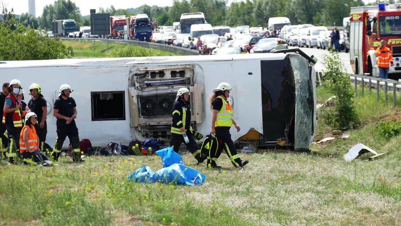 Umgekippter Reisebus an der Autobahn: Rettungskräfte sind an der Unfallstelle im Einsatz.