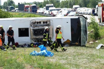 Umgekippter Reisebus an der Autobahn: Rettungskräfte sind an der Unfallstelle im Einsatz.