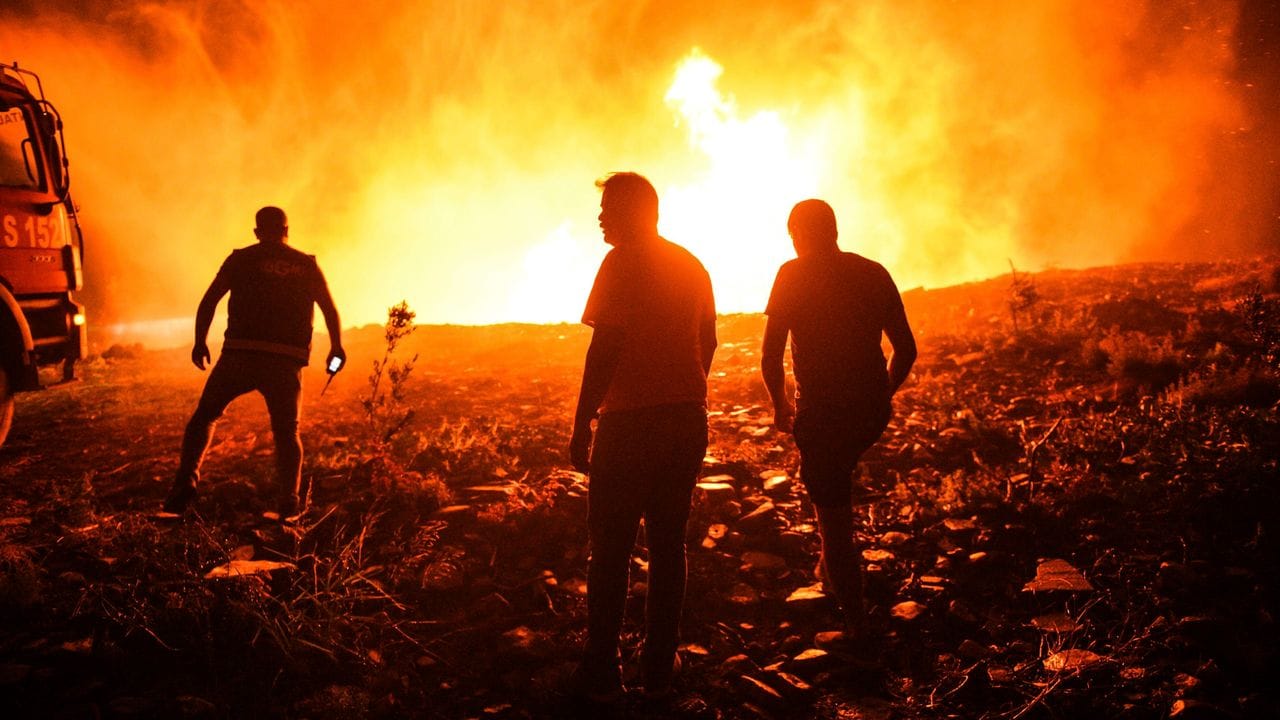 Feuerwehrleute und Dorfbewohner versuchen, ein Feuer in der Provinz Antalya unter Kontrolle zu bringen.