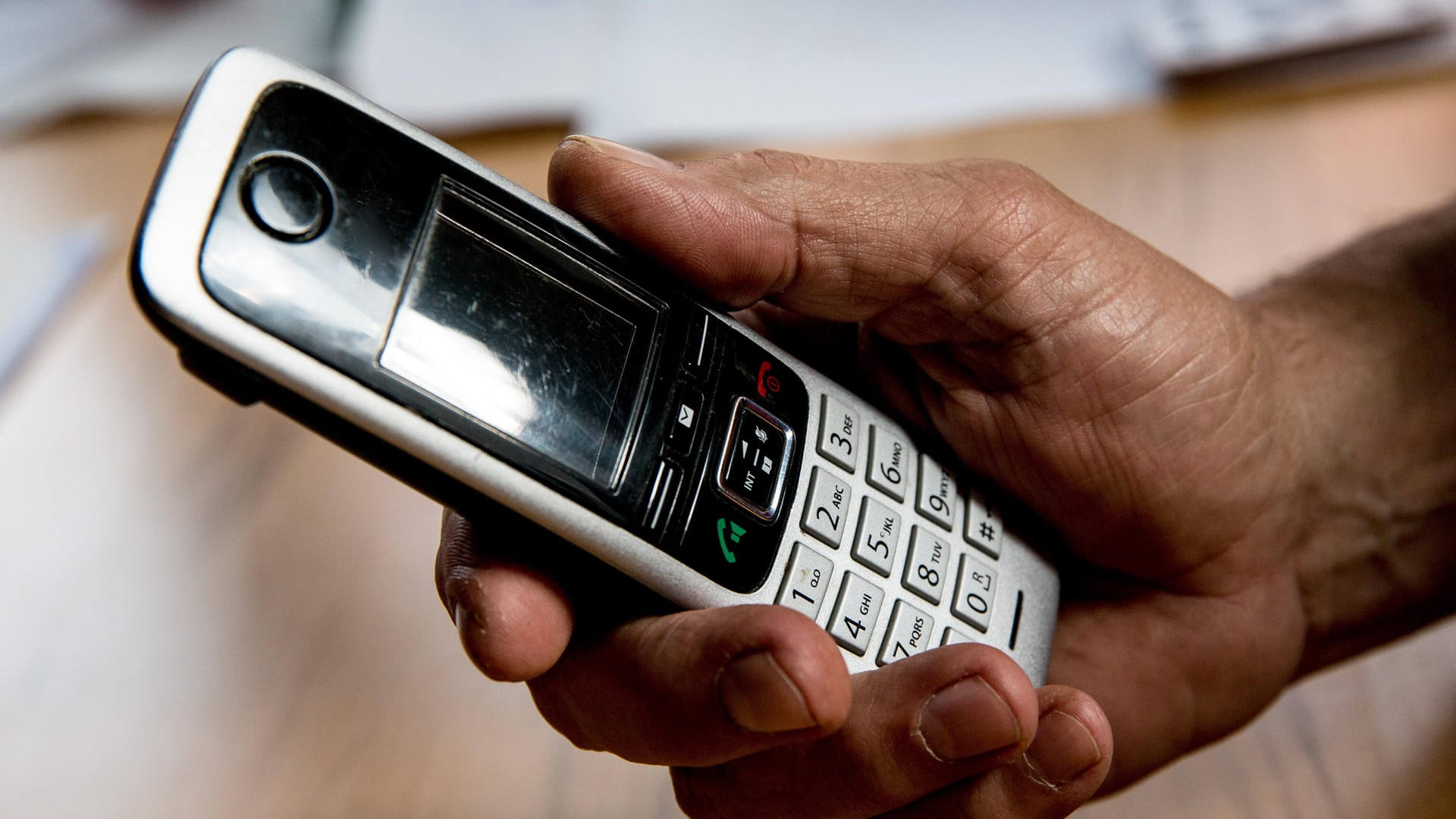 Jemand hält ein Telefon in der Hand (Symbolbild): Zusammen mit ihrer Schwester konnte die angerufene Seniorin den Anruf als Betrug entlarven.