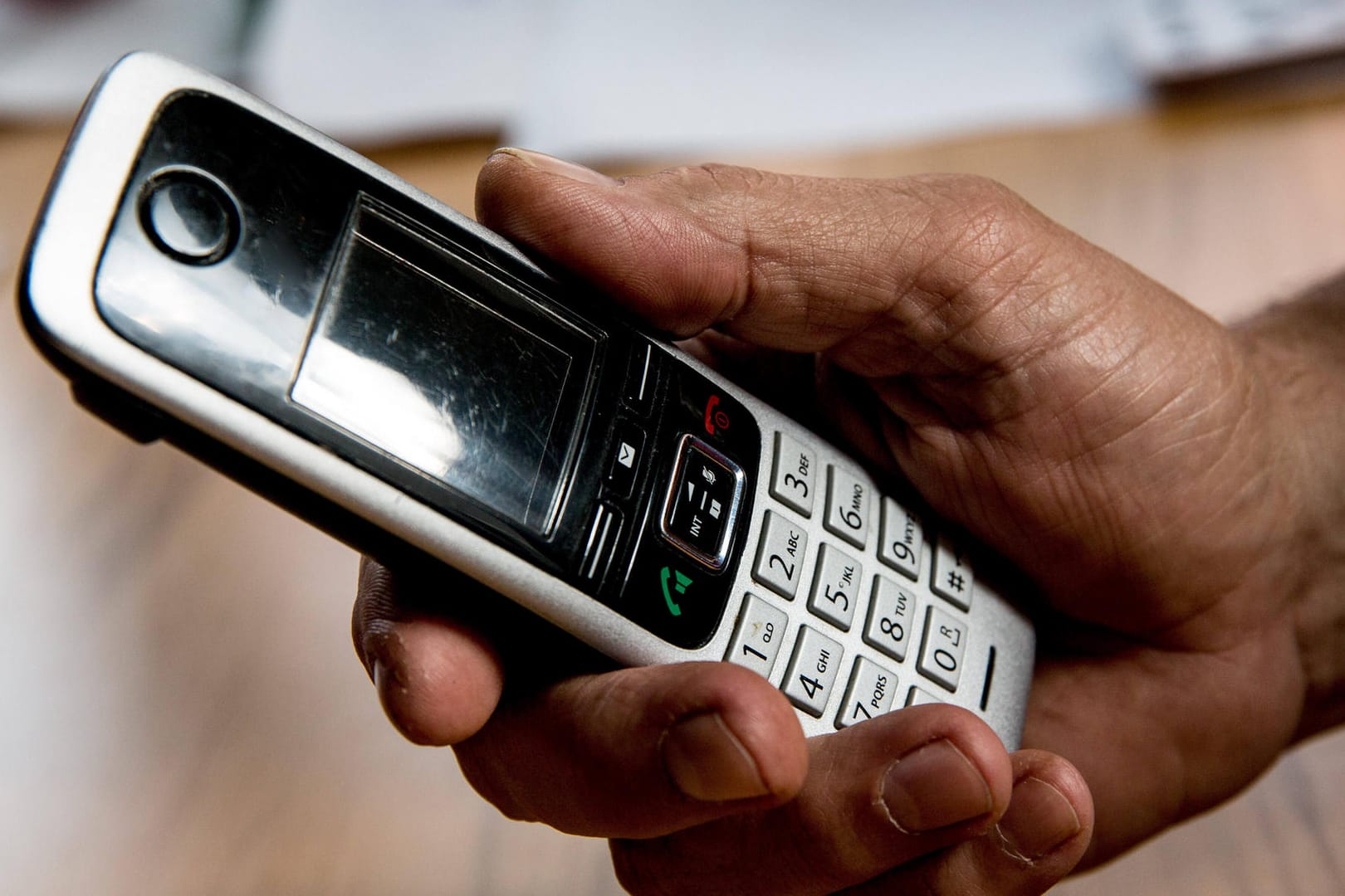 Jemand hält ein Telefon in der Hand (Symbolbild): Zusammen mit ihrer Schwester konnte die angerufene Seniorin den Anruf als Betrug entlarven.