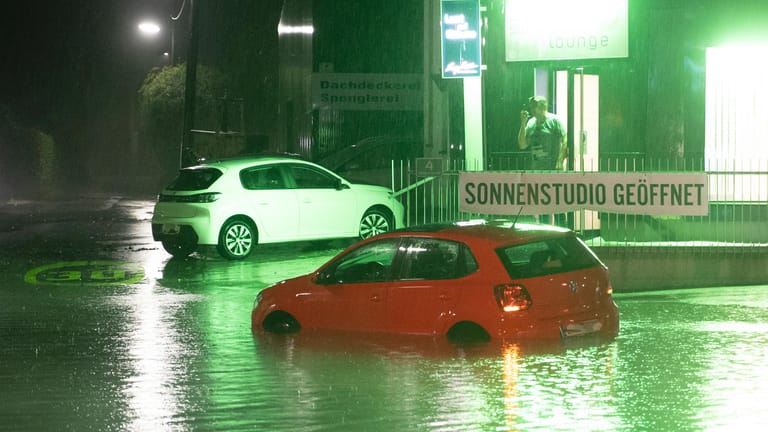 Ein Fahrzeug steht in Graz auf einer überfluteten Kreuzung nach schweren Unwettern.