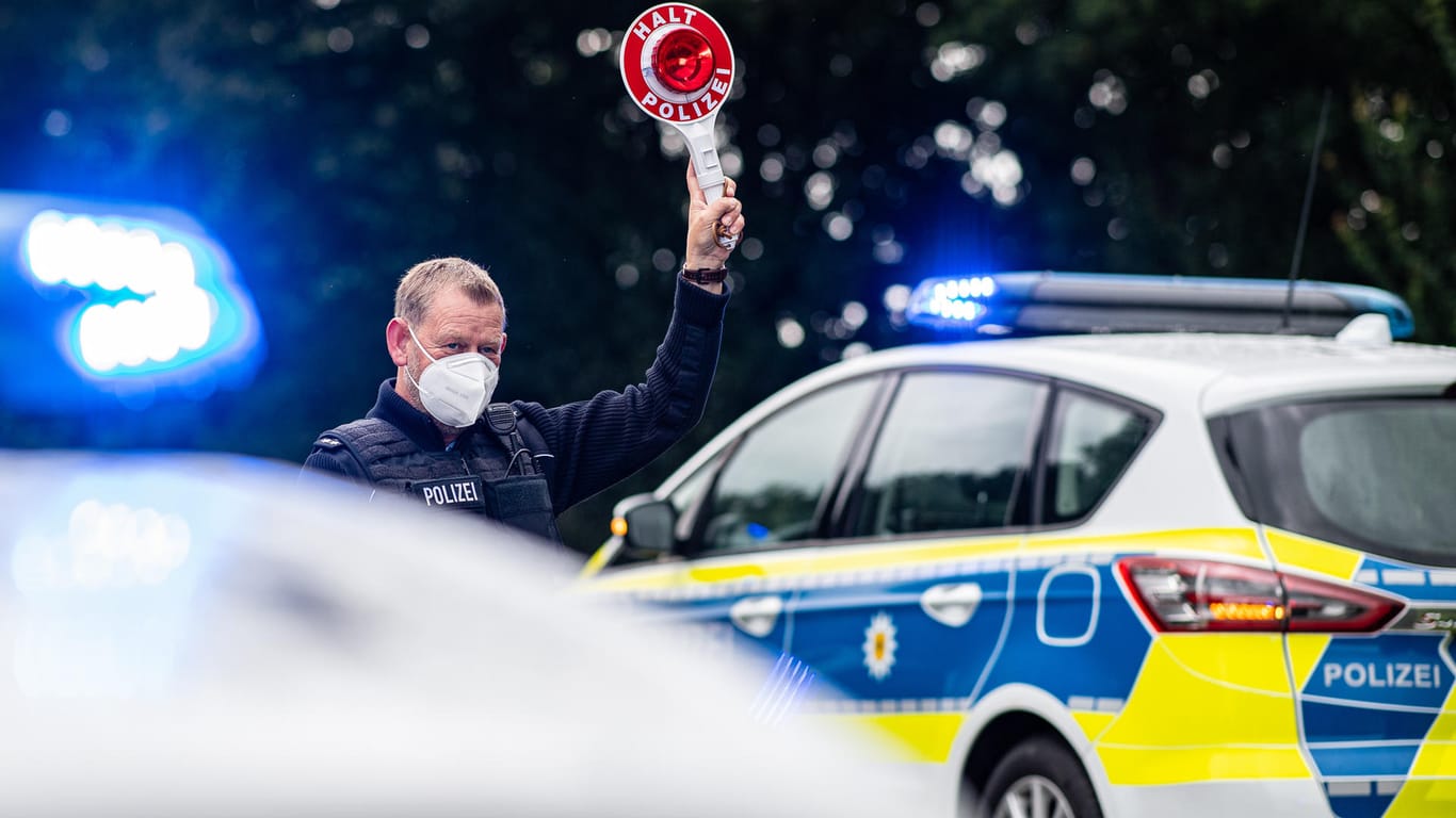 Ein Polizeibeamter kontrolliert Einreisende an der Grenze zu den Niederlanden (Archivbild). Seit heute gelten strengere Einreiseregeln für Rückkehrer aus dem Urlaub.
