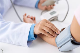 Ein Arzt misst den Blutdruck.