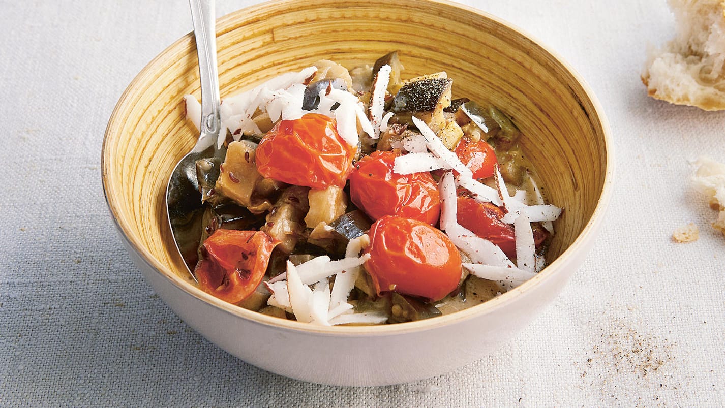 Auberginen mit Kokossoße und Tomaten: Zum Schluss wird das Gericht mit dem geraspelten Kokosnussfleisch garniert.