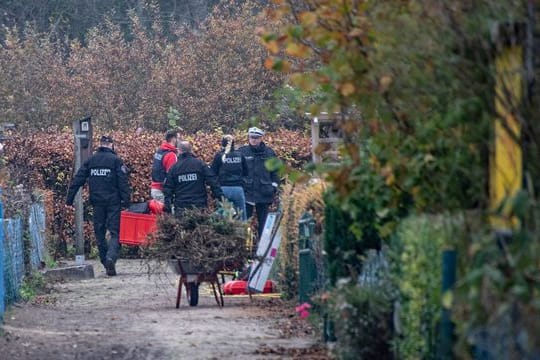 Polizisten tragen eine Kiste aus einer Parzelle einer Kleingartenanlage (Archivbild): In der Kleingartenanlage soll sich der Angeklagte häufig aufgehalten haben.