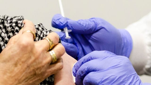 Die Einstichstelle am Arm einer Frau in Kiel wird nach dem Impfen desinfiziert (Symbolbild): Deutsche Unternehmen erwägen eine Impfpflicht für Mitarbeiter in den USA. Die Einstichstelle am Arm einer Frau in Kiel wird nach dem Impfen desinfiziert (Symbolbild): Deutsche Unternehmen erwägen eine Impfpflicht für Mitarbeiter in den USA.