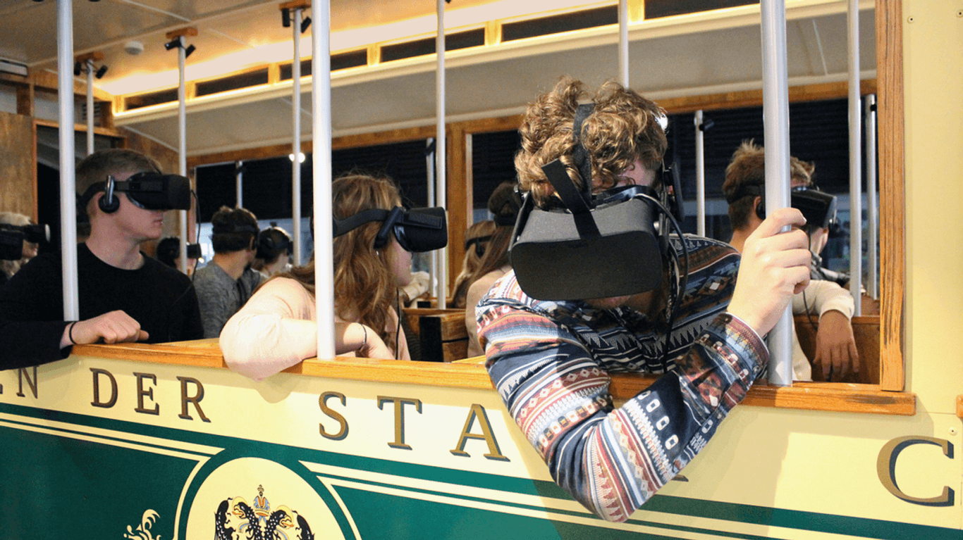 Passagiere im originalgetreuen Nachbau einer historischen Straßenbahn (Aufnahme vor Corona-Pandemie): Mit der VR-Brille geht es auf die Tour.