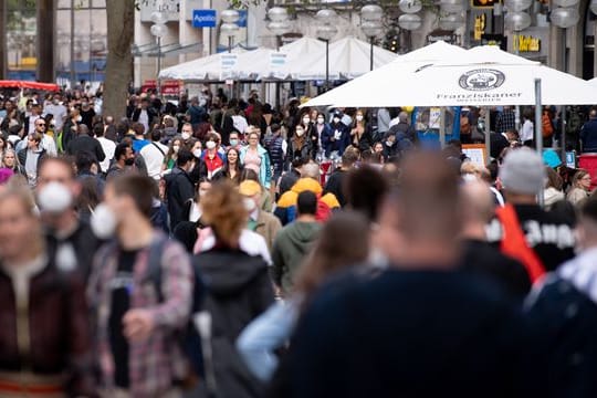 Zahlreiche Menschen spazieren durch die Münchner Fußgängerzone in der Innenstadt.