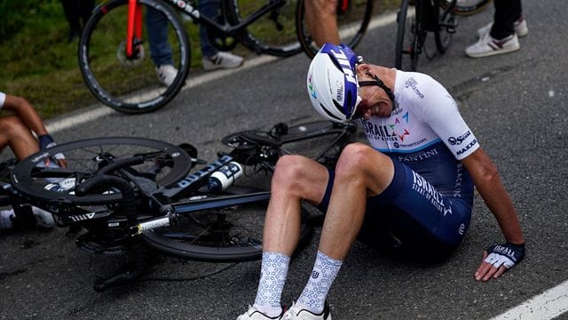 Chris Froome sitzt nach dem Sturz auf der Straße.