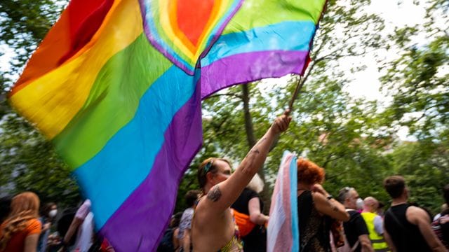 Ein Teilnehmer der "CSD Berlin Pride" trägt eine Regenbogenfarbene Flagge mit einem Herz. Ein Teilnehmer der "CSD Berlin Pride" trägt eine Regenbogenfarbene Flagge mit einem Herz.