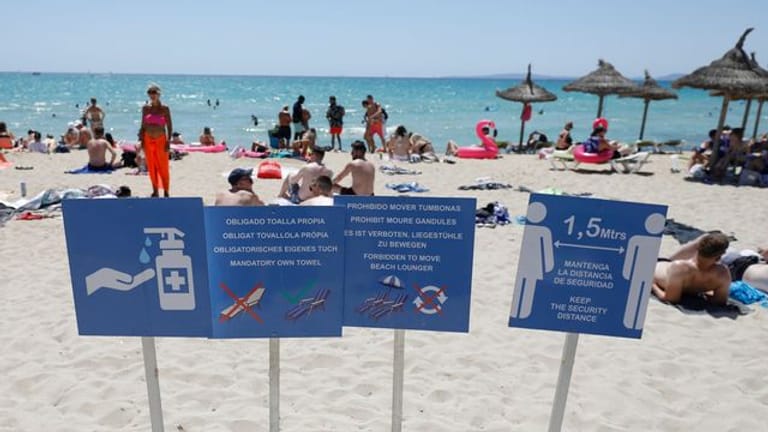 Touristen halten sich am Strand von Arenal in Palma de Mallorca auf.