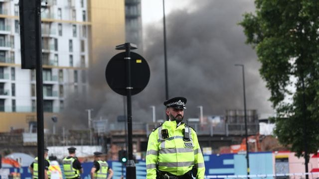 Polizisten richteten einen Sicherheitsbereich um den Brand in der Nähe des Bahnhofs Elephant and Castle in Süd-London ein. Polizisten richteten einen Sicherheitsbereich um den Brand in der Nähe des Bahnhofs Elephant and Castle in Süd-London ein.