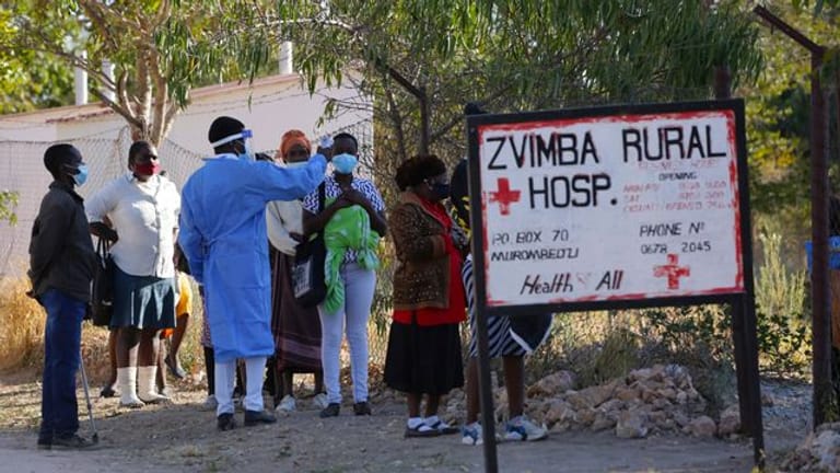 Bewohnern wird in Zvimba, Simbabwe, die Temperatur gemessen, bevor sie sich im örtlichen Krankenhaus behandeln lassen können.