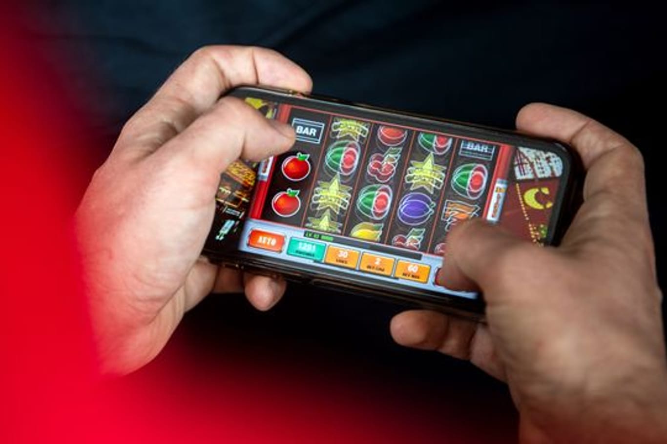 Auf einem Smartphone spielt ein Mann ein Online-Spiel.