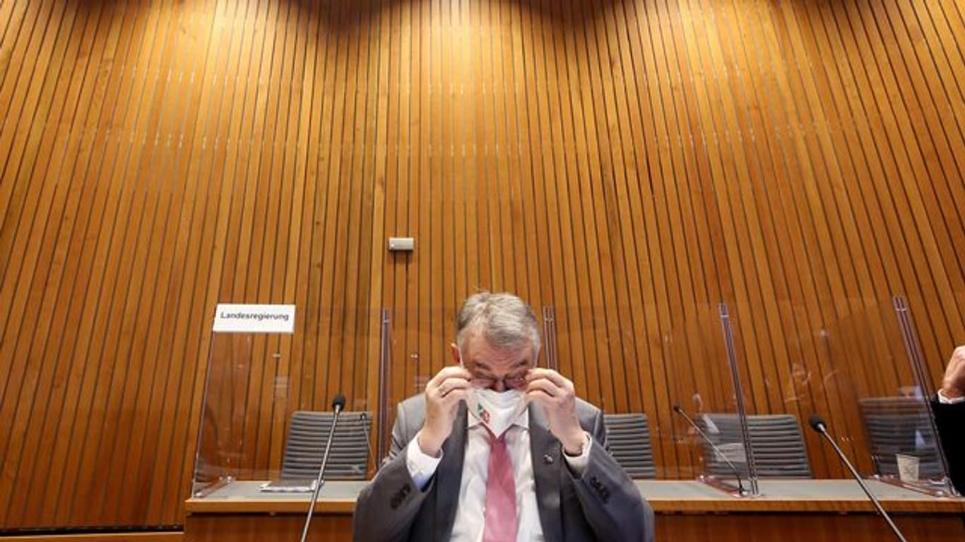 Herbert Reul (CDU) setzt sich vor Beginn der Sitzung des Innenausschusses die Brille auf.