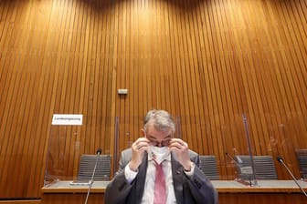 Herbert Reul (CDU) setzt sich vor Beginn der Sitzung des Innenausschusses die Brille auf.