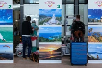 Eine erste Gruppe von Touristen wird nach der Ankunft am Phuket International Airport auf Corona getestet.