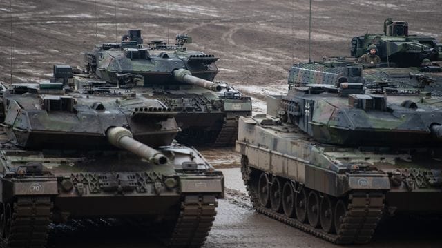 Drei Kampfpanzer der Bundeswehr vom Typ Leopard 2A6 und ein Schützenpanzer vom Typ Puma stehen bei einer Übung im Gelände. Drei Kampfpanzer der Bundeswehr vom Typ Leopard 2A6 und ein Schützenpanzer vom Typ Puma stehen bei einer Übung im Gelände.