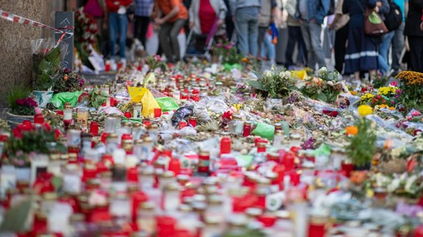 Kerzen, Grablichter und Blumen liegen vor einem Kaufhaus in der Innenstadt, in dem ein Mann vor einer Woche Menschen mit einem Messer attackiert und getötet hatte.