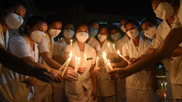 Krankenschwestern erinnern mit Kerzen an die verstorbenen Ärzte, die ihr Leben durch Corona verloren haben. Krankenschwestern erinnern mit Kerzen an die verstorbenen Ärzte, die ihr Leben durch Corona verloren haben.