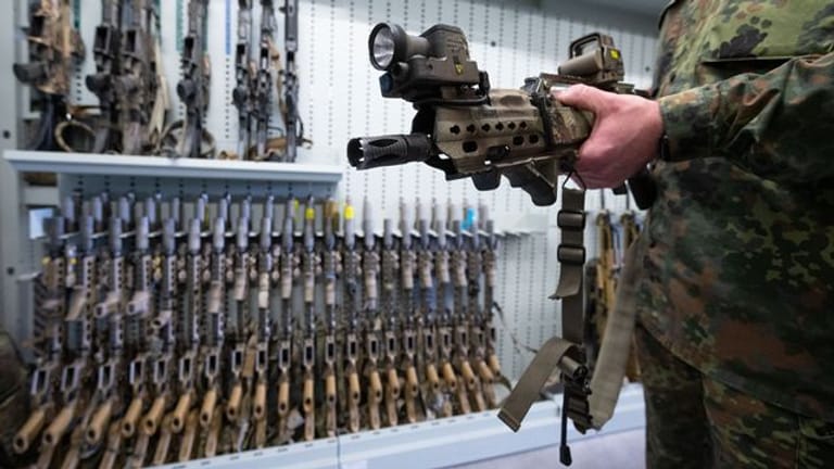 Ein spezielles Modell des G36-Sturmgewehrs von Heckler & Koch zeigt ein Soldat der Bundeswehr in einer Waffenkammer.